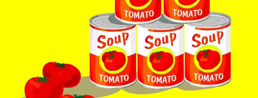 Bright canned tomato soup with fresh tomatoes on vibrant yellow background.