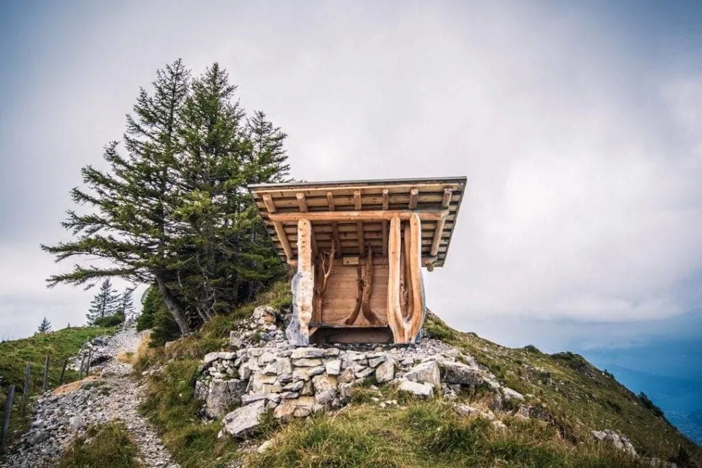 Rustic mountain hut with wooden construction on alpine hillside.