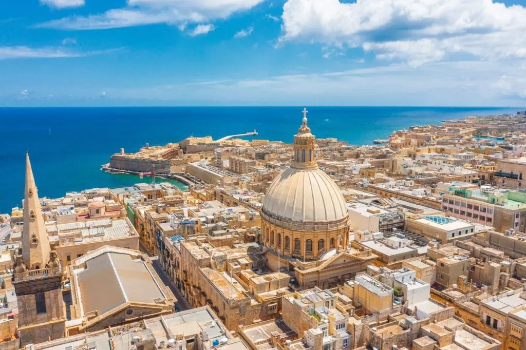 Panoramic view of Malta with historic buildings and blue sea, sunny weather.