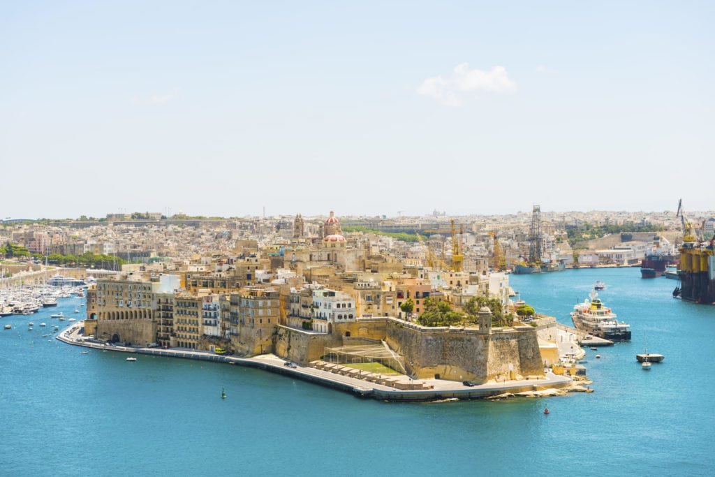 Historic southern Maltese town with coastline views and maritime activity.