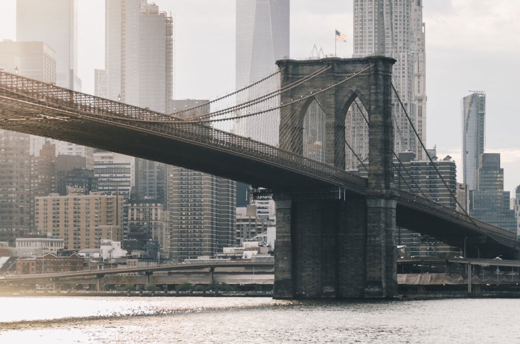 Suspension bridge and city skyline representing long-term infrastructure investment