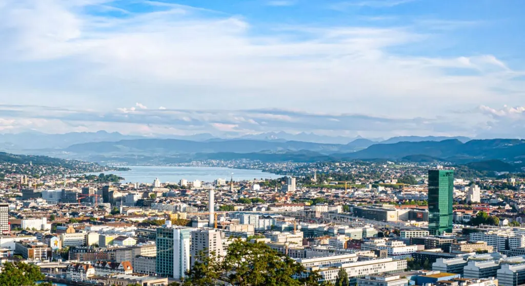 Panoramic view of Zurich city with lake and mountains in the background.