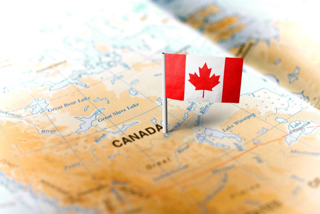 Canadian flag on a map of Canada showing lakes and rivers.