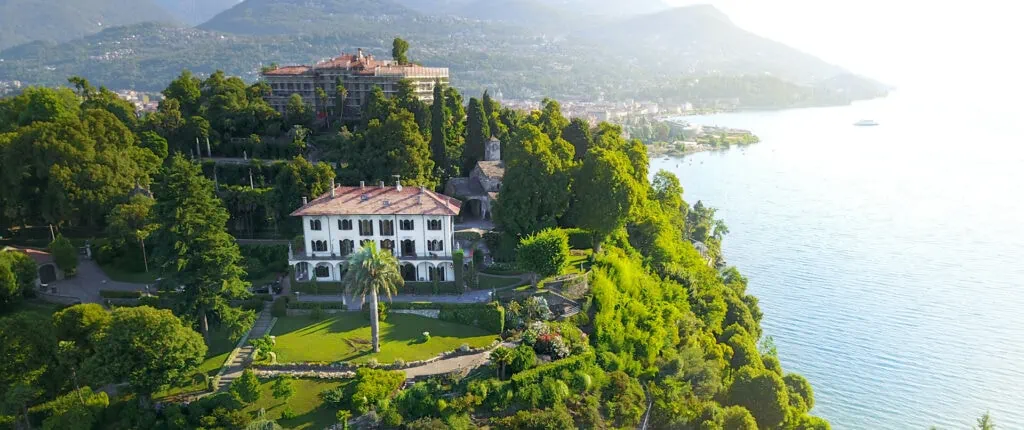 Luxurious lakeside villa surrounded by lush greenery and scenic water views.
