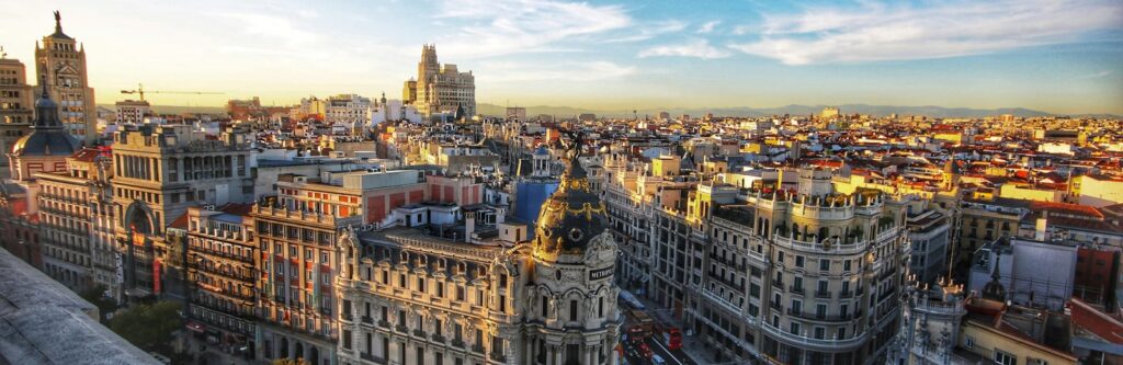 Vibrant Madrid cityscape with historic buildings and iconic architecture in golden sunset light.