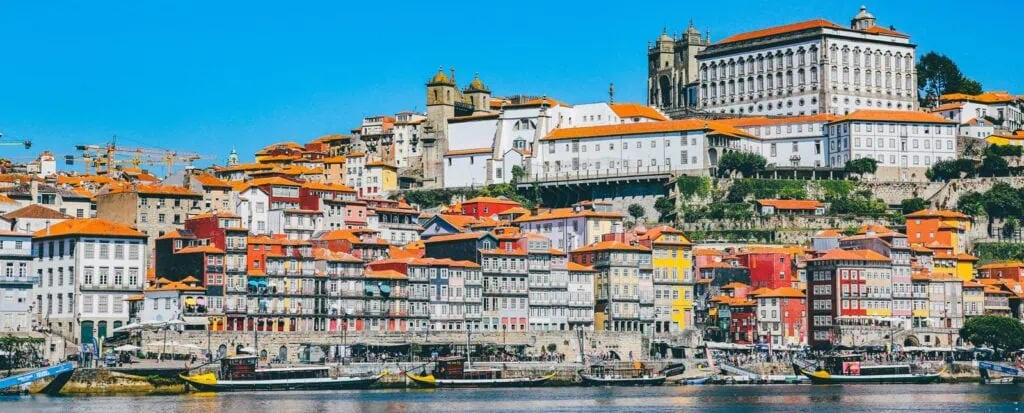 Colorful historic Porto Ribeira district in Portugal with riverfront views.