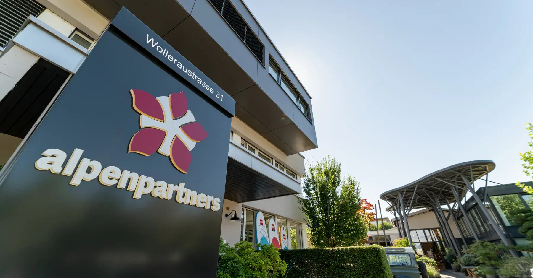 Modern office building exterior with Alpen Partners logo and signage, Wolleraustrasse 31.
