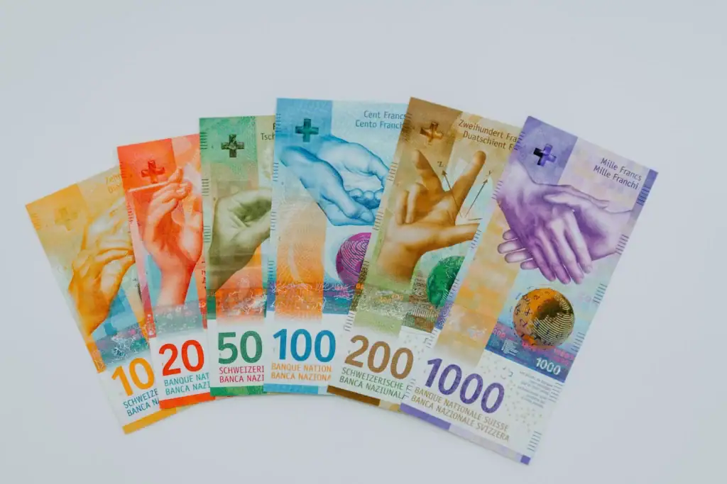 Colourful Swiss banknotes displaying denominations from 10 to 1000 francs, focusing on currency and finance.