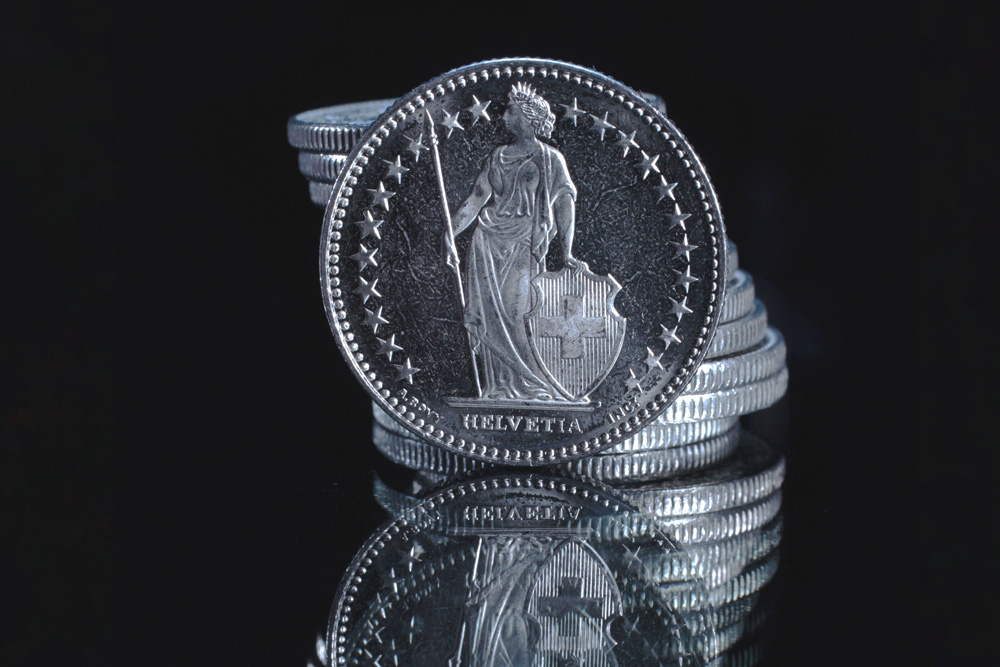 Swiss Franc coin stacked with others, close-up image.