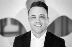 Professional portrait of a smiling man in a suit at Alpen Partners AG office.