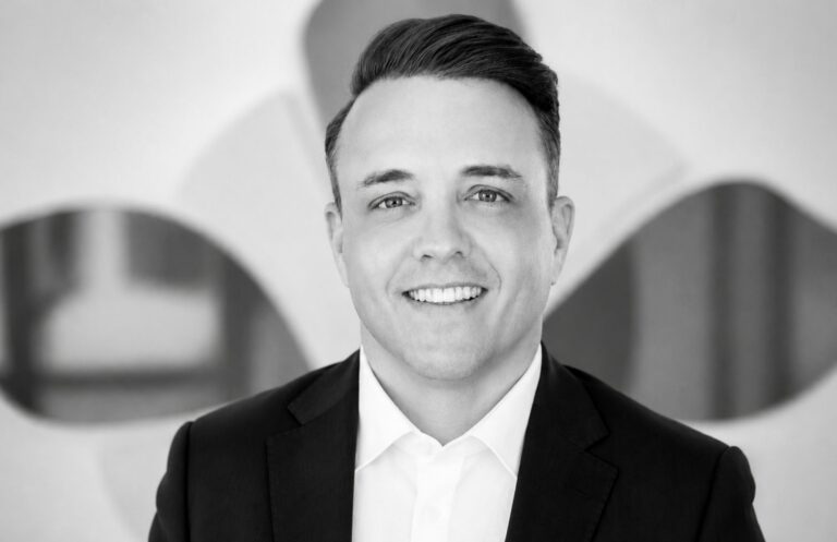 Professional portrait of a smiling man in a suit at Alpen Partners AG office.