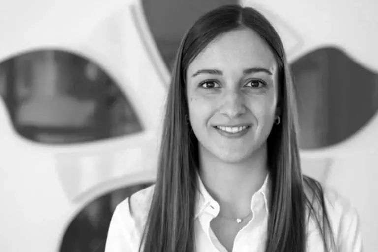 Businesswoman smiling in office with modern decor at Alpen Partners AG.