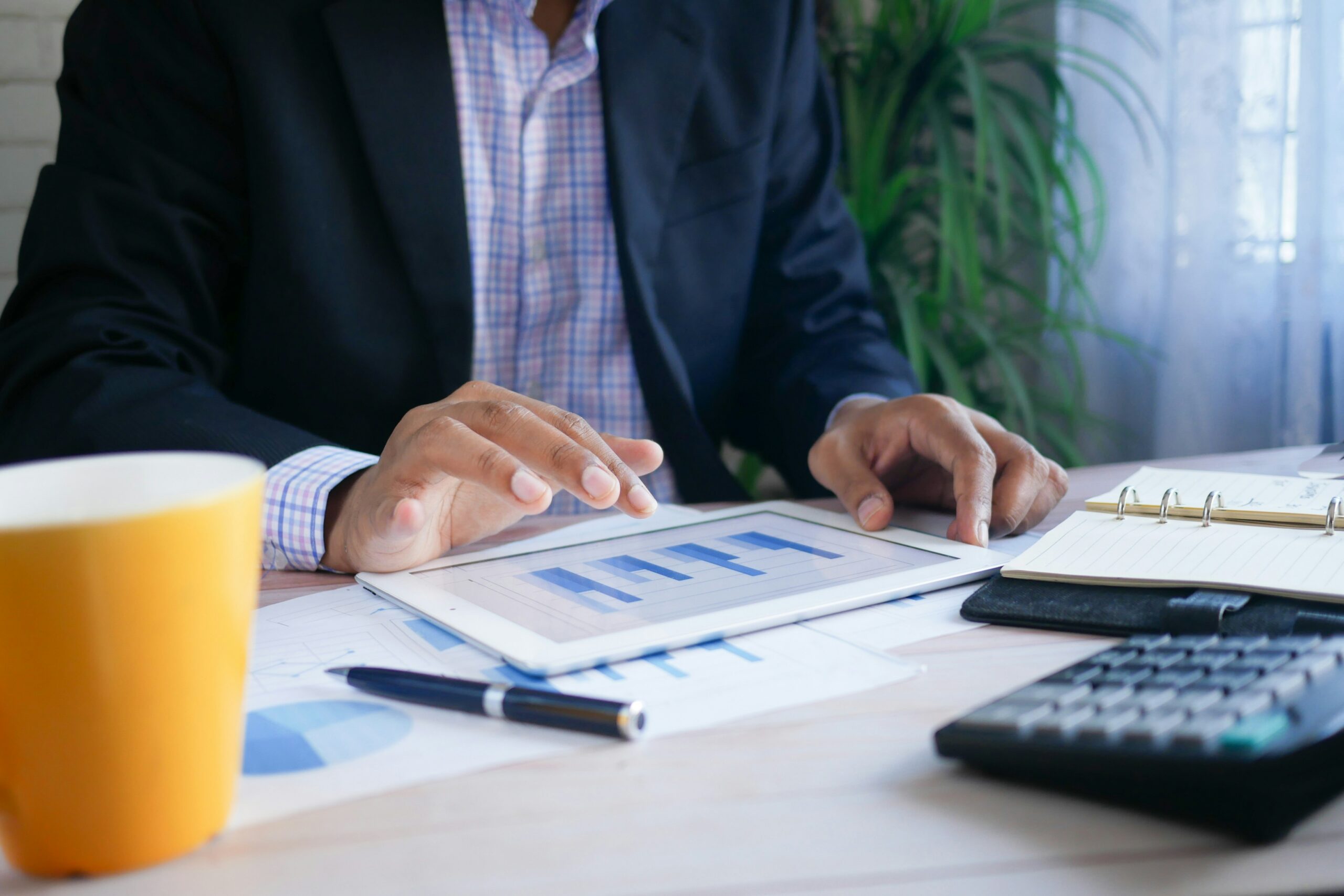 Businessman reviewing financial charts and documents at desk.
