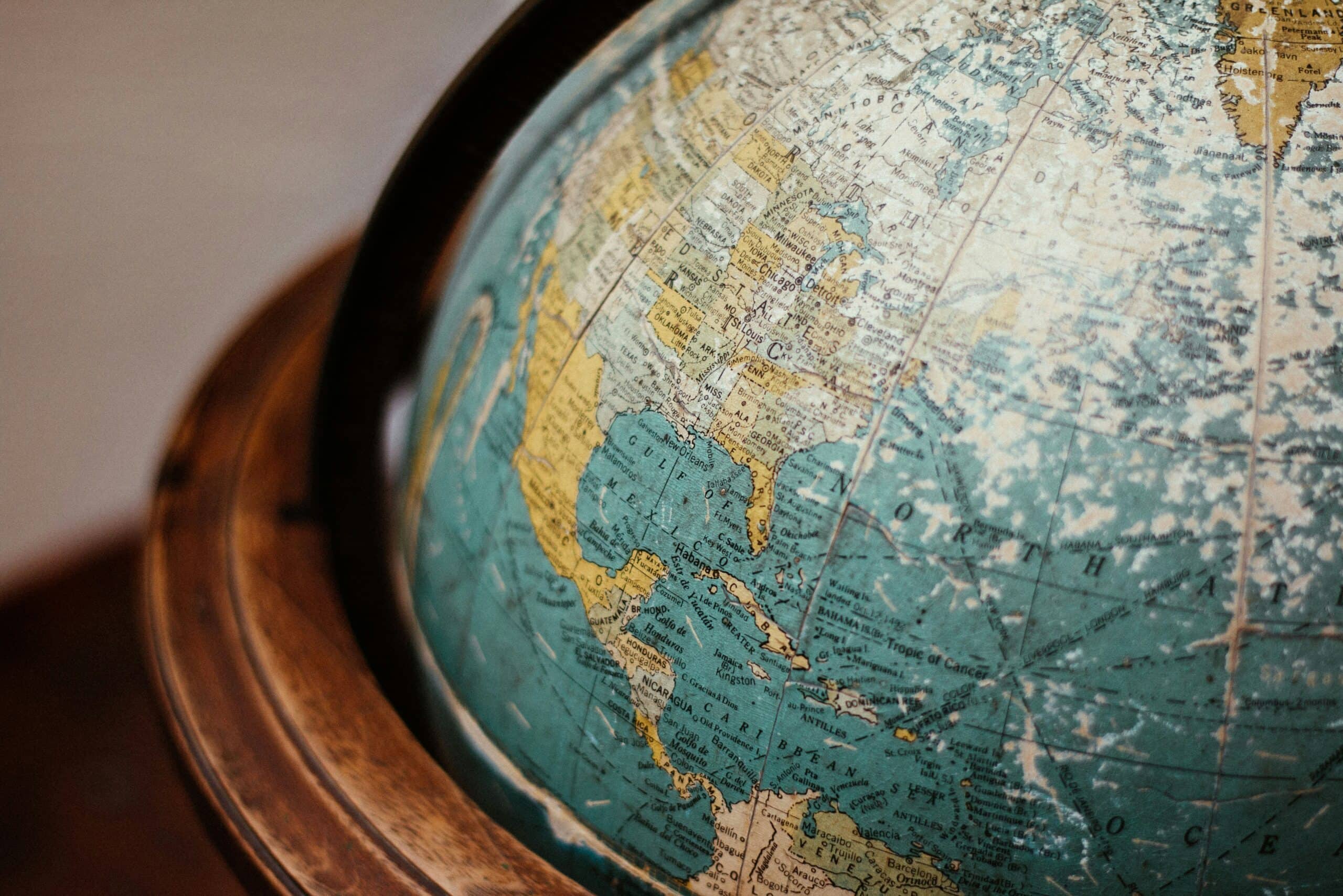 Close-up of a vintage globe on a wooden stand, showing North America and the North Atlantic