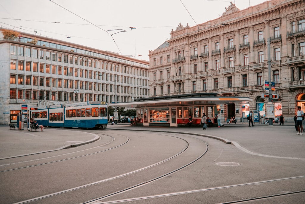 Tram in Zurich city square with historic architecture and modern buildings.