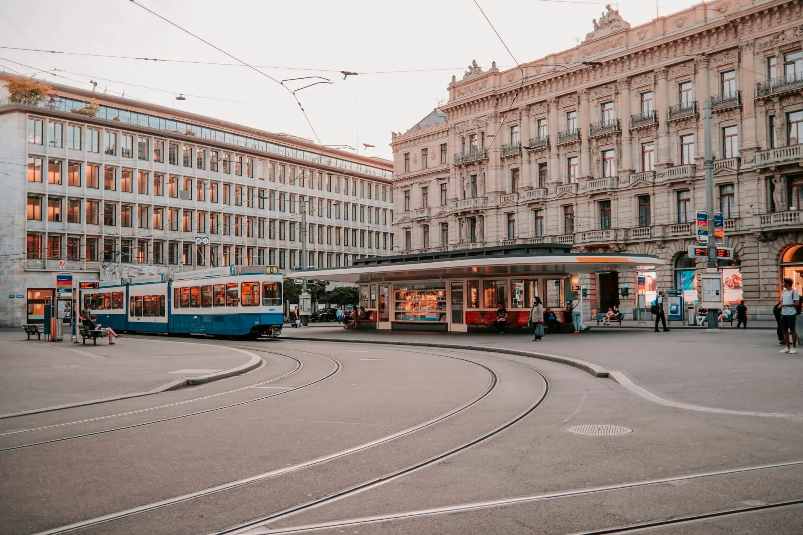 Tram in Zurich city square with historic architecture and modern buildings.