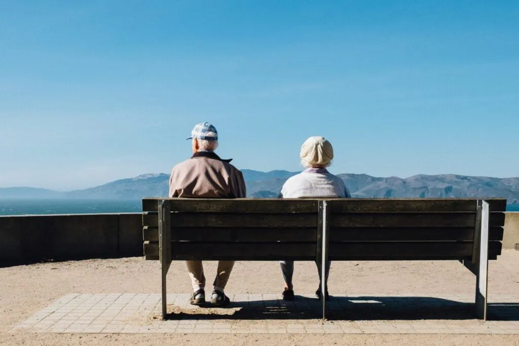 woman and man sitting on a bench, retirment
