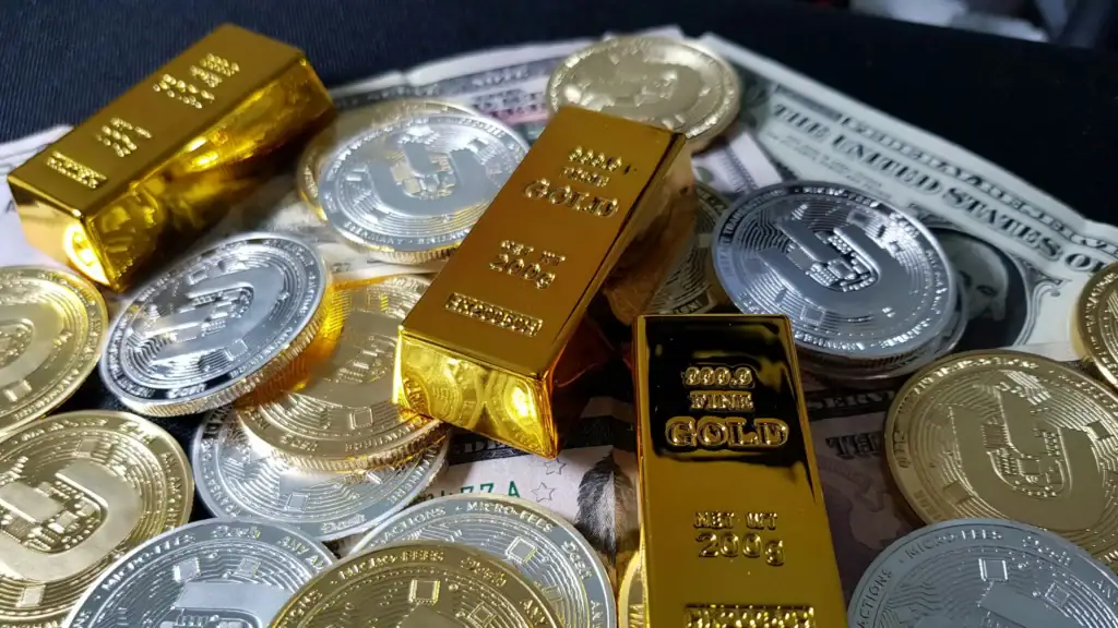 Gold and silver coins with US dollar bills, financial investment concept.